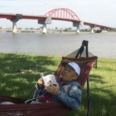 「自然との調和：大川市の大野島でのハンモック読書」バックには新田大橋